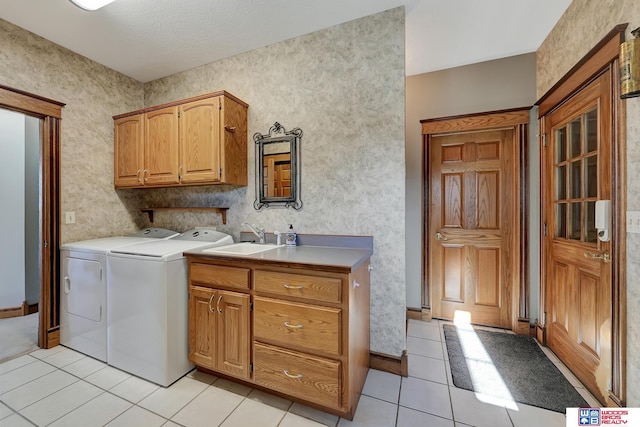 washroom featuring cabinets, independent washer and dryer, sink, and light tile patterned floors