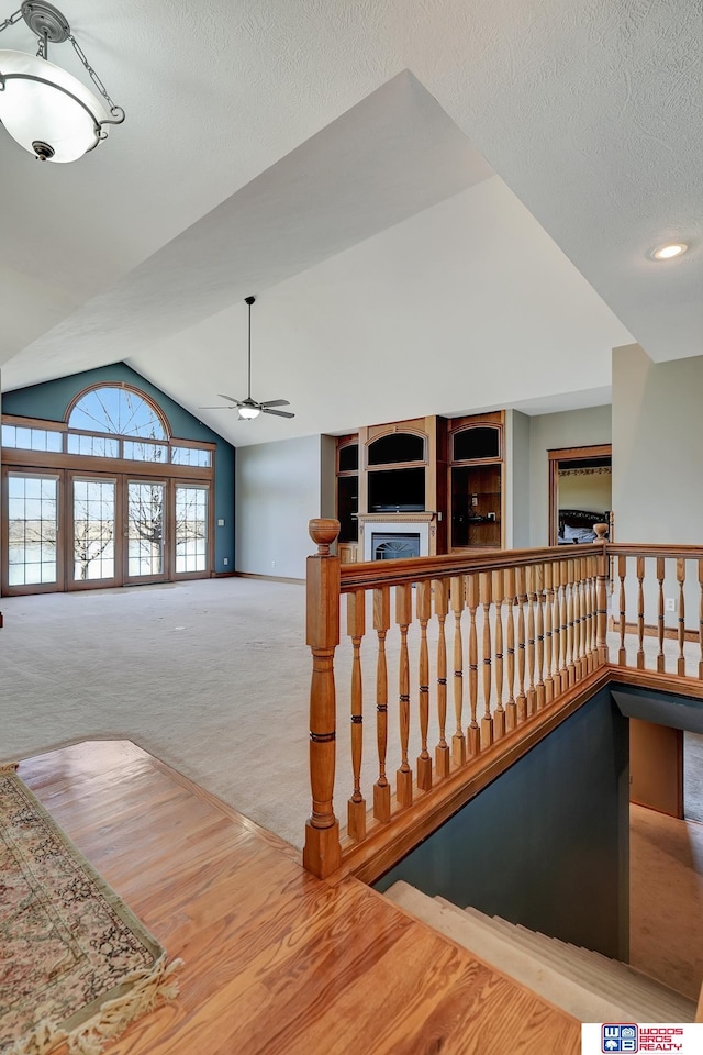 stairs featuring a textured ceiling, carpet floors, vaulted ceiling, and ceiling fan