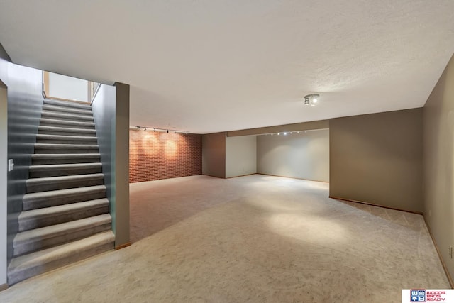 basement with light colored carpet and track lighting