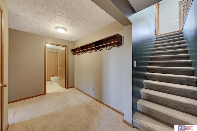 interior space featuring a textured ceiling and light carpet