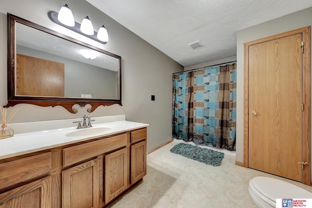 bathroom with vanity, a textured ceiling, and toilet