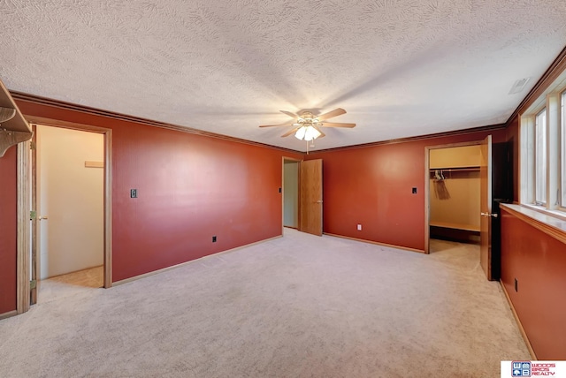 unfurnished bedroom featuring ceiling fan, light colored carpet, ornamental molding, and a closet