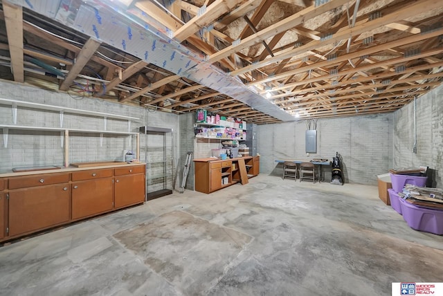 basement featuring brick wall and electric panel