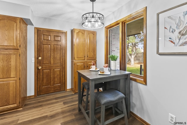 dining space with a textured ceiling and dark hardwood / wood-style floors