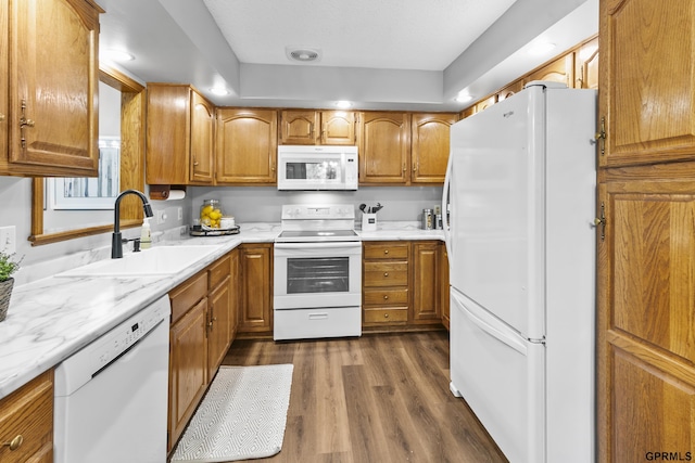 kitchen featuring dark hardwood / wood-style floors, white appliances, and sink