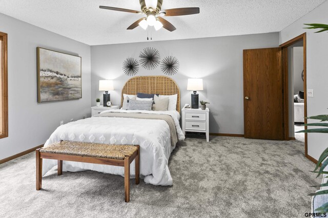 carpeted bedroom with ceiling fan and a textured ceiling