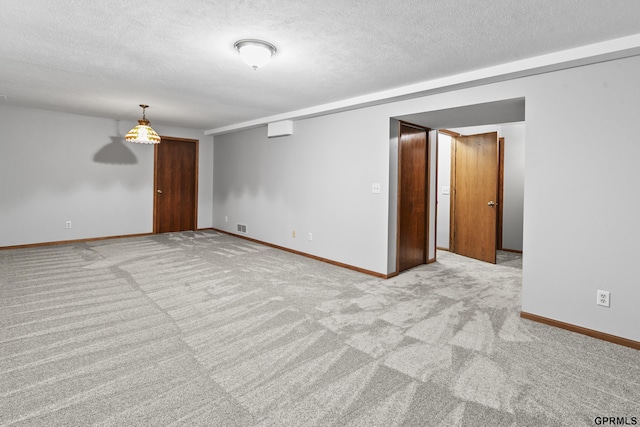 carpeted spare room with a textured ceiling