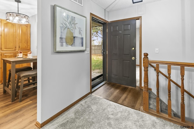 entrance foyer with light hardwood / wood-style flooring and a notable chandelier