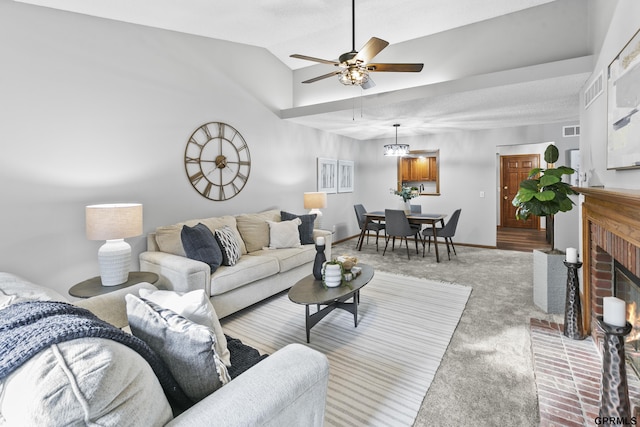 carpeted living room with ceiling fan, a fireplace, and vaulted ceiling