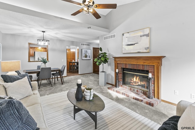 living room with a fireplace, light carpet, and ceiling fan