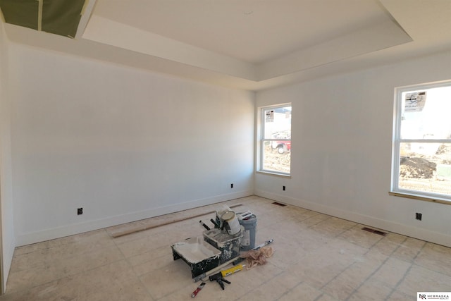 empty room with a wealth of natural light and a tray ceiling