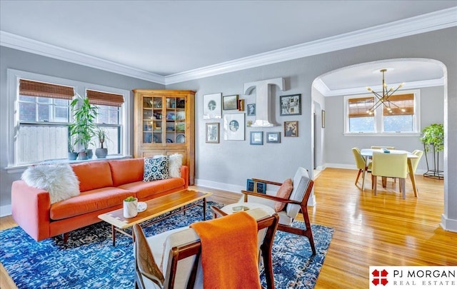 living room featuring crown molding, wood-type flooring, and an inviting chandelier