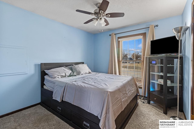 carpeted bedroom with ceiling fan and a textured ceiling