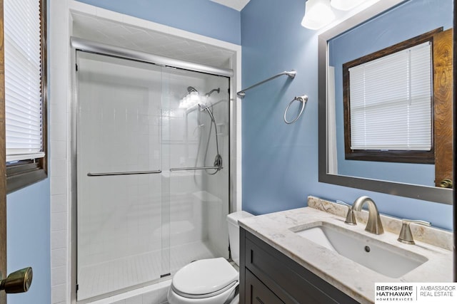 bathroom featuring toilet, vanity, and walk in shower