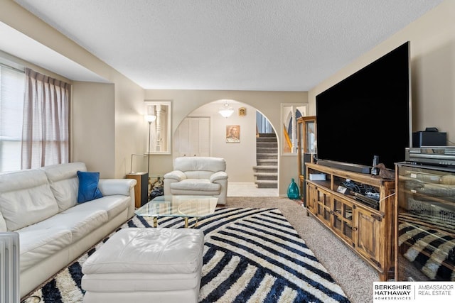 carpeted living room featuring a textured ceiling