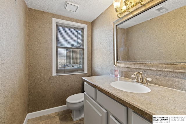 bathroom with vanity, tile patterned floors, a textured ceiling, and toilet