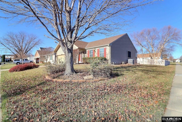 view of side of property featuring a lawn, a garage, and central AC