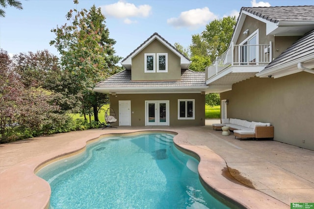 view of pool featuring outdoor lounge area, a patio, and french doors