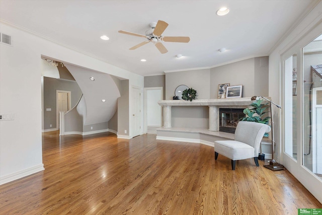 sitting room with hardwood / wood-style floors, ceiling fan, and crown molding