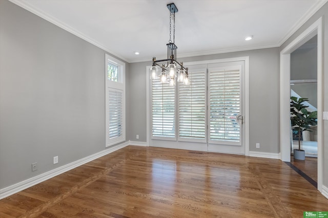 unfurnished dining area featuring a chandelier, wood-type flooring, and ornamental molding