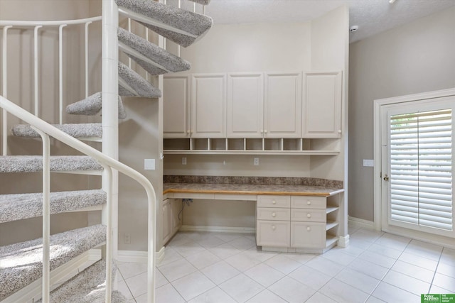 interior space featuring light tile patterned floors and built in desk