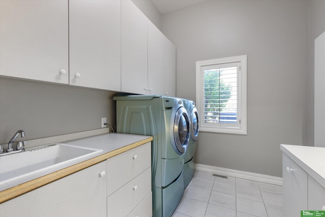 laundry area featuring cabinets, light tile patterned floors, sink, and washing machine and dryer