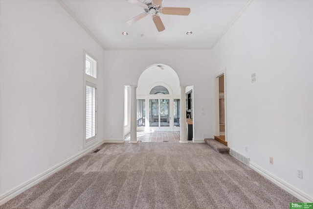 unfurnished living room with ceiling fan, ornamental molding, light carpet, and ornate columns