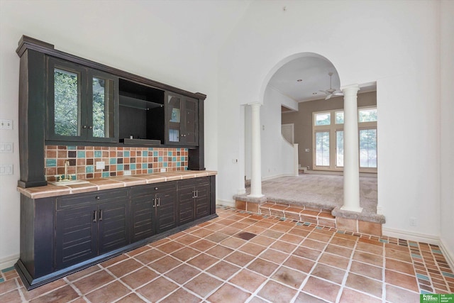 kitchen featuring decorative backsplash, dark brown cabinetry, ceiling fan, and a healthy amount of sunlight