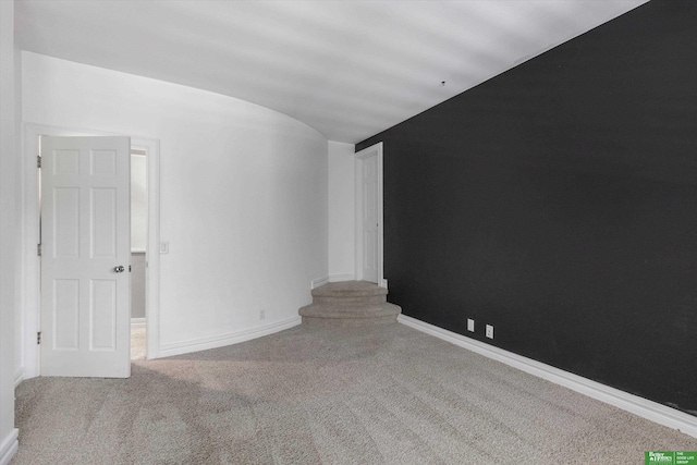 carpeted empty room with lofted ceiling