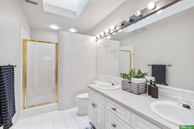 bathroom with a skylight, walk in shower, tile patterned flooring, toilet, and vanity