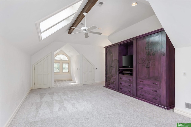 bonus room with vaulted ceiling with skylight, ceiling fan, and light carpet