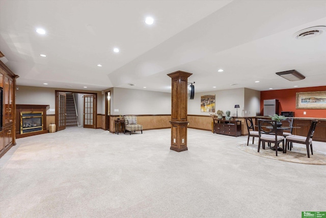 living room with light colored carpet, ornate columns, and lofted ceiling