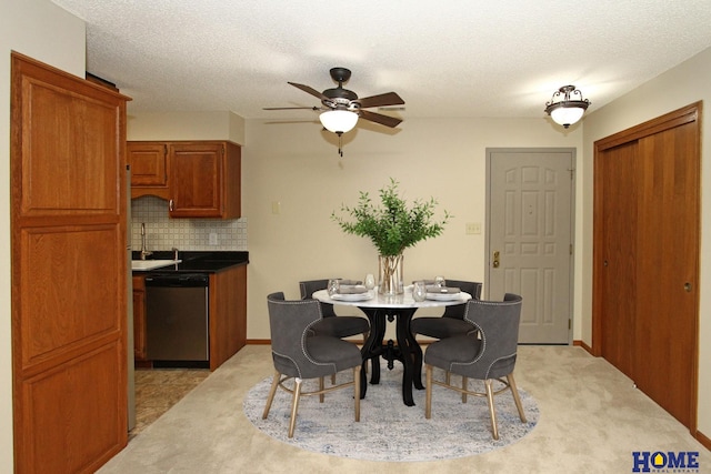 carpeted dining room featuring a textured ceiling, ceiling fan, and sink