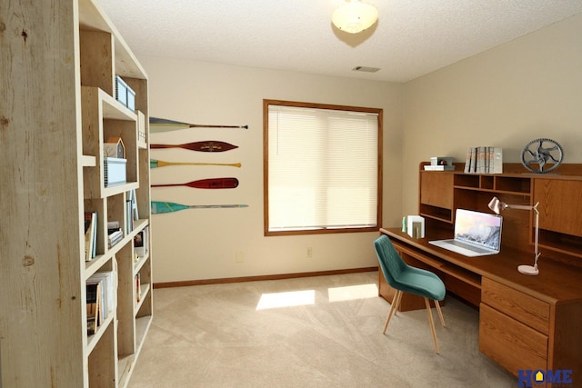 carpeted office featuring a textured ceiling