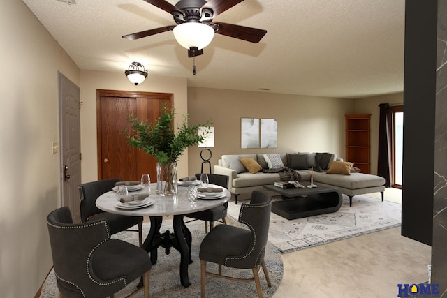 carpeted living room with ceiling fan and a textured ceiling