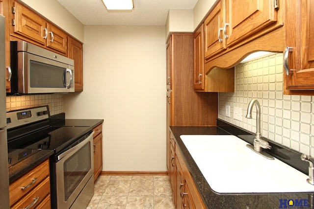 kitchen with decorative backsplash, appliances with stainless steel finishes, a textured ceiling, and sink