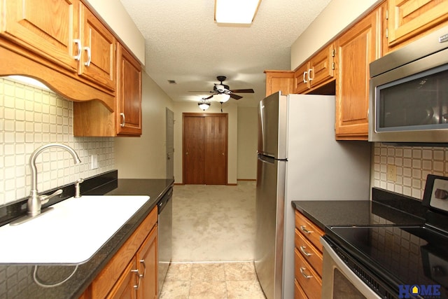 kitchen with tasteful backsplash, stainless steel appliances, ceiling fan, and sink