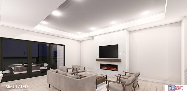 living room with light hardwood / wood-style floors, a high end fireplace, and a tray ceiling