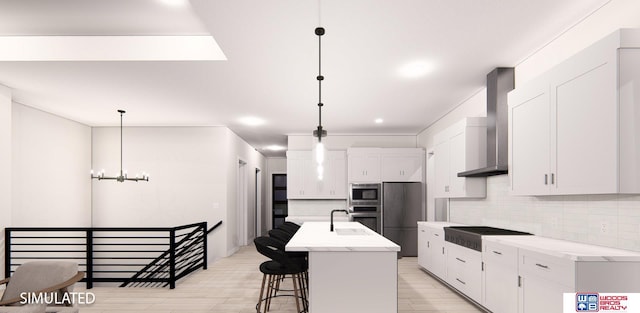 kitchen featuring appliances with stainless steel finishes, decorative light fixtures, a kitchen island with sink, and wall chimney exhaust hood