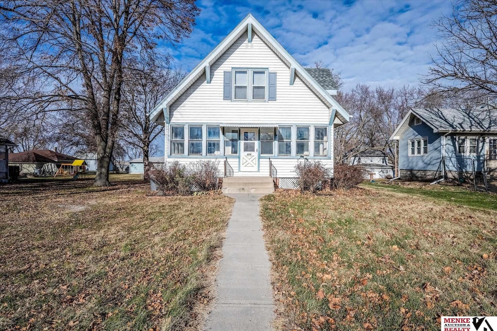 view of front of property with a sunroom and a front lawn