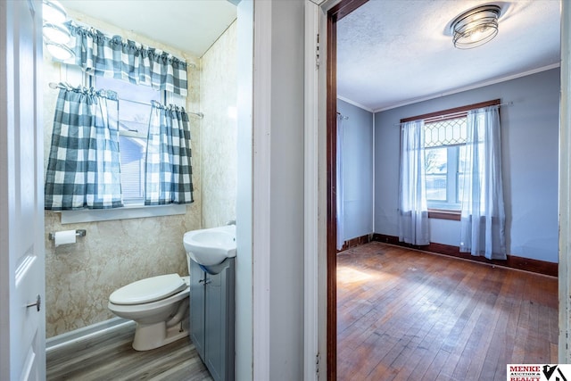 bathroom with crown molding, hardwood / wood-style floors, vanity, and toilet