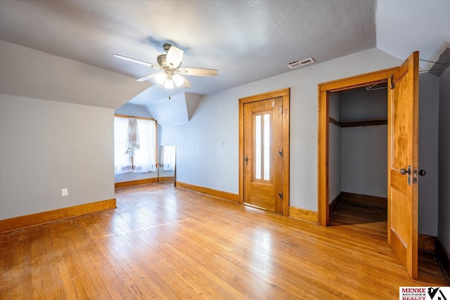 interior space with ceiling fan, a spacious closet, light hardwood / wood-style flooring, a closet, and lofted ceiling