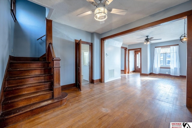 interior space featuring ceiling fan, light hardwood / wood-style floors, and a textured ceiling