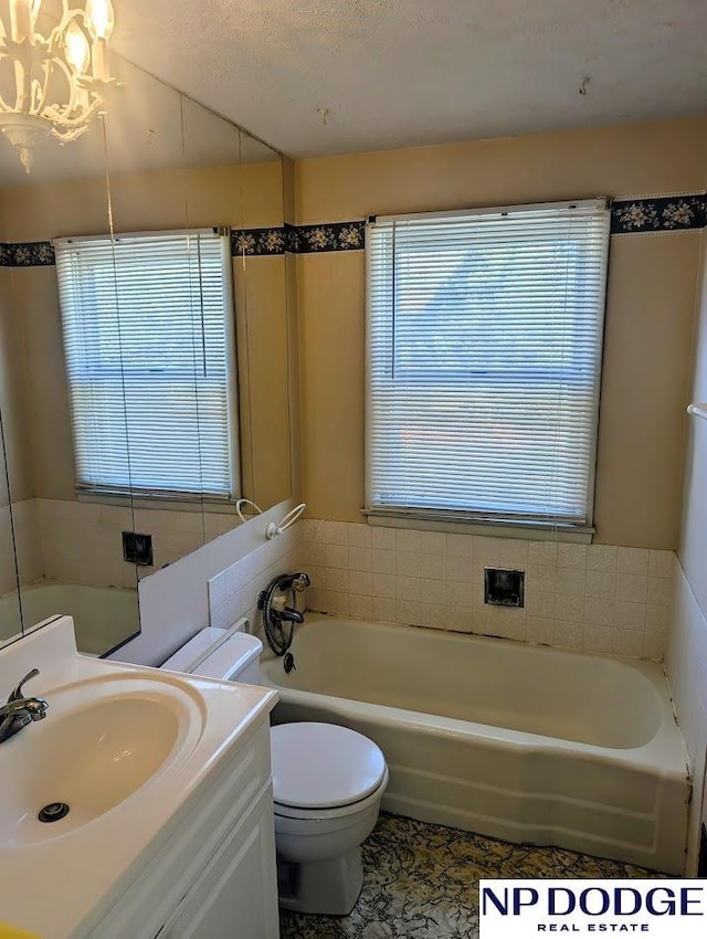 bathroom featuring plenty of natural light, vanity, a textured ceiling, and toilet