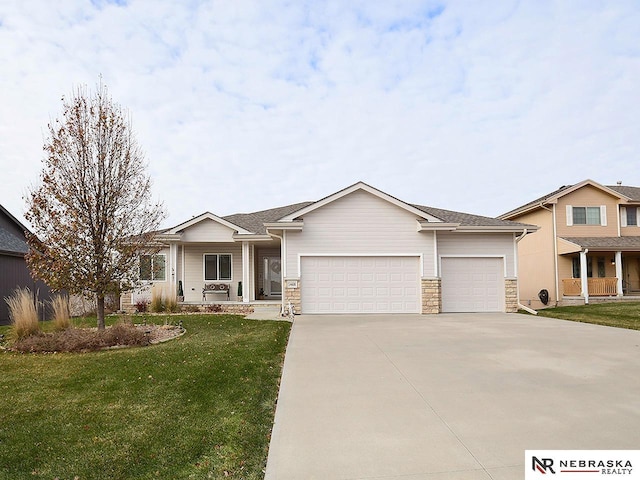 view of front of property with a garage, covered porch, and a front lawn