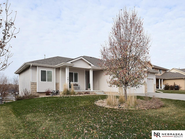 view of front of home featuring a front yard, a garage, and covered porch