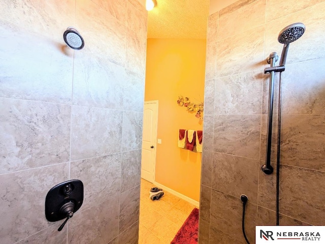 bathroom featuring a textured ceiling and a tile shower