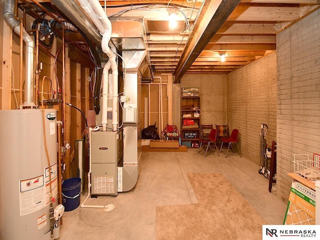 basement with brick wall, heating unit, and gas water heater