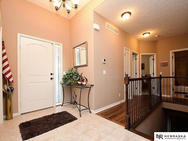 tiled entrance foyer featuring a textured ceiling