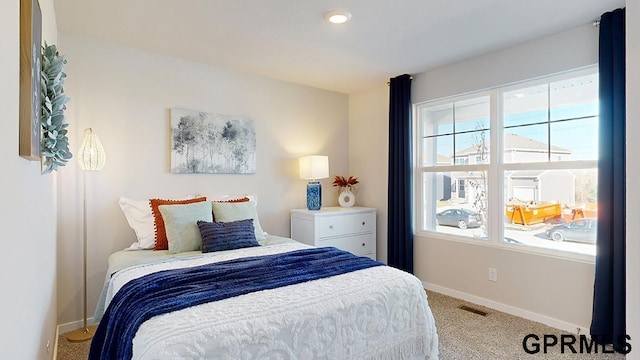 bedroom featuring light carpet and multiple windows